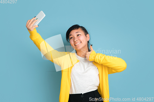 Image of Asian teenager\'s portrait isolated on blue studio background