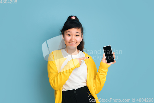 Image of Asian teenager\'s portrait isolated on blue studio background