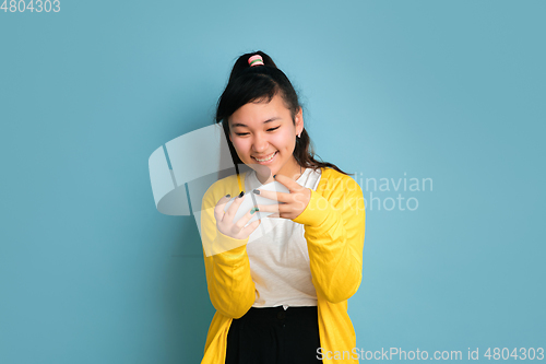 Image of Asian teenager\'s portrait isolated on blue studio background