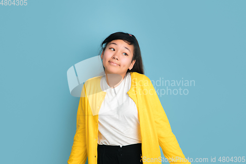 Image of Asian teenager\'s portrait isolated on blue studio background