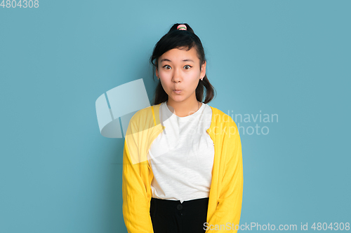 Image of Asian teenager\'s portrait isolated on blue studio background