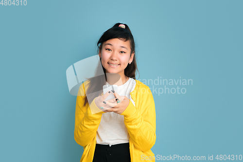 Image of Asian teenager\'s portrait isolated on blue studio background