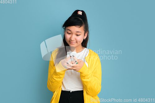 Image of Asian teenager\'s portrait isolated on blue studio background