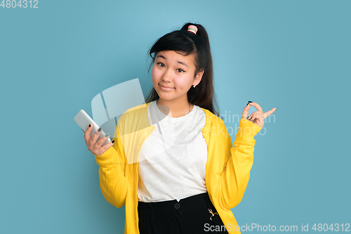 Image of Asian teenager\'s portrait isolated on blue studio background