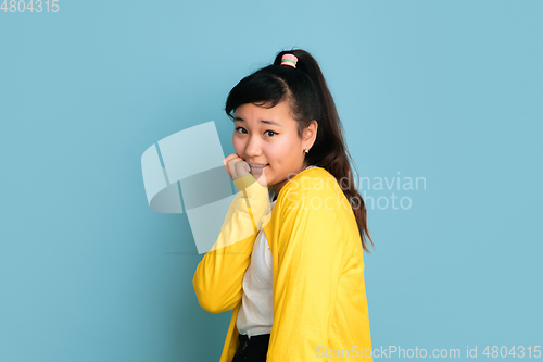 Image of Asian teenager\'s portrait isolated on blue studio background