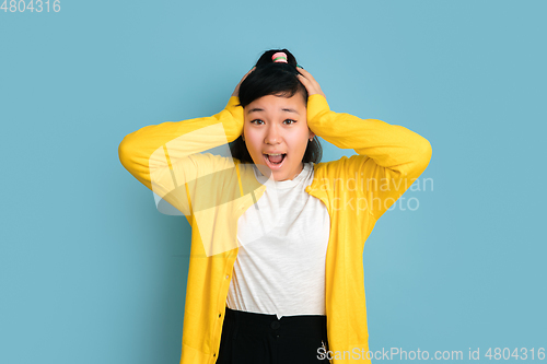 Image of Asian teenager\'s portrait isolated on blue studio background
