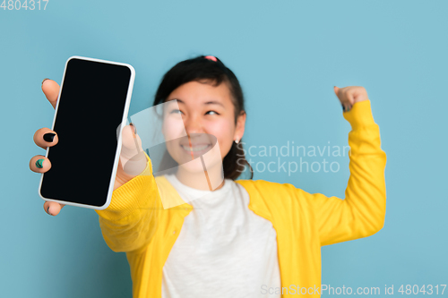 Image of Asian teenager\'s portrait isolated on blue studio background