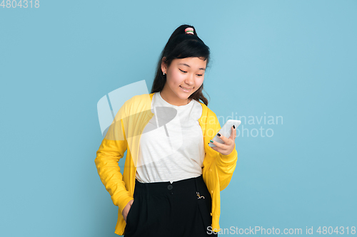 Image of Asian teenager\'s portrait isolated on blue studio background
