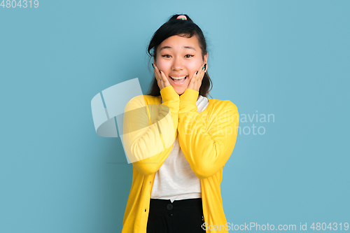 Image of Asian teenager\'s portrait isolated on blue studio background