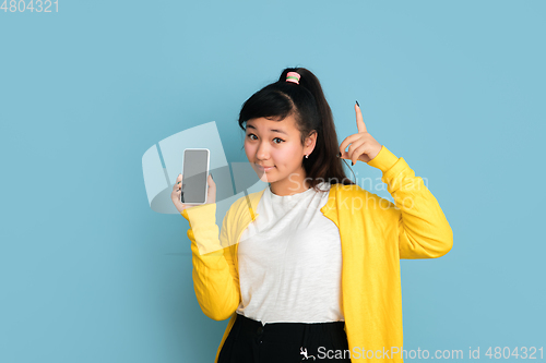 Image of Asian teenager\'s portrait isolated on blue studio background