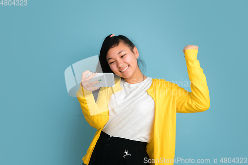 Image of Asian teenager\'s portrait isolated on blue studio background