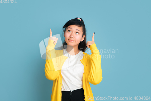 Image of Asian teenager\'s portrait isolated on blue studio background