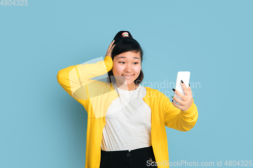 Image of Asian teenager\'s portrait isolated on blue studio background