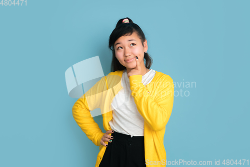 Image of Asian teenager\'s portrait isolated on blue studio background
