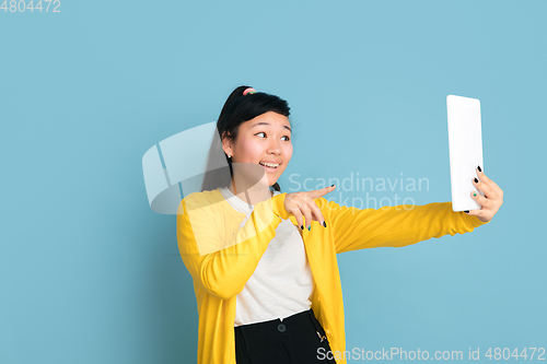 Image of Asian teenager\'s portrait isolated on blue studio background