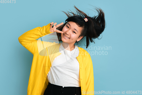 Image of Asian teenager\'s portrait isolated on blue studio background