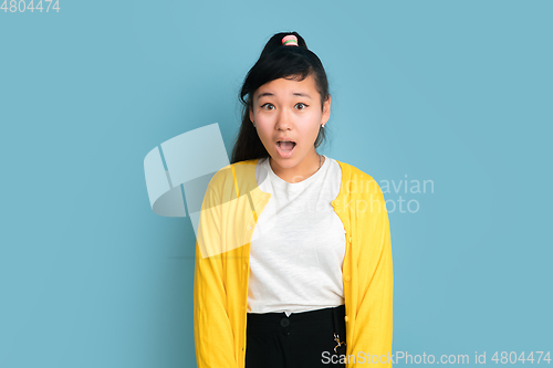 Image of Asian teenager\'s portrait isolated on blue studio background