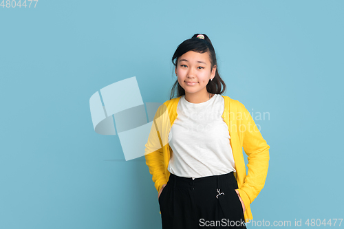 Image of Asian teenager\'s portrait isolated on blue studio background