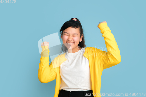 Image of Asian teenager\'s portrait isolated on blue studio background