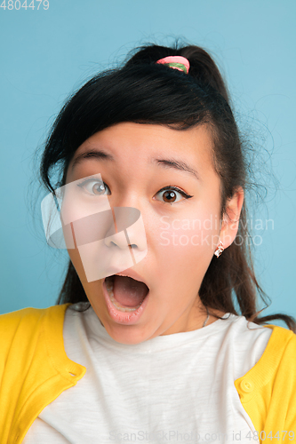 Image of Asian teenager\'s close up portrait isolated on blue studio background