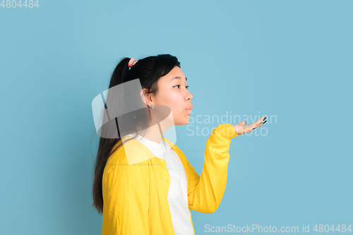 Image of Asian teenager\'s portrait isolated on blue studio background