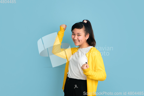 Image of Asian teenager\'s portrait isolated on blue studio background
