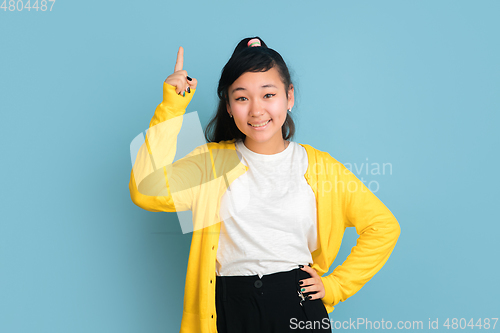 Image of Asian teenager\'s portrait isolated on blue studio background