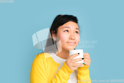 Image of Asian teenager\'s portrait isolated on blue studio background
