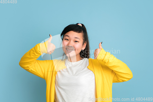 Image of Asian teenager\'s portrait isolated on blue studio background