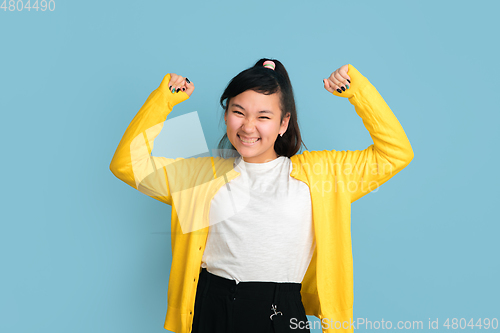 Image of Asian teenager\'s portrait isolated on blue studio background