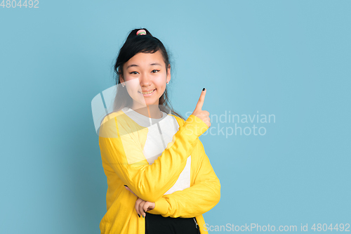 Image of Asian teenager\'s portrait isolated on blue studio background