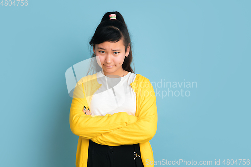 Image of Asian teenager\'s portrait isolated on blue studio background
