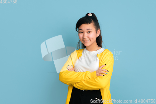 Image of Asian teenager\'s portrait isolated on blue studio background