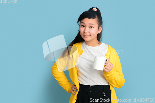 Image of Asian teenager\'s portrait isolated on blue studio background