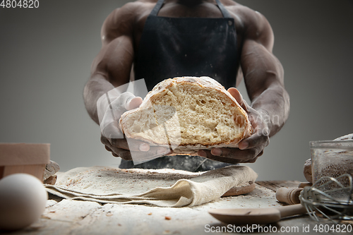 Image of Close up of african-american man cooks bread at craft kitchen