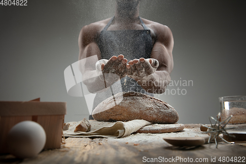 Image of Close up of african-american man cooks bread at craft kitchen