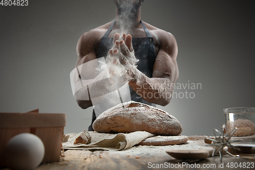 Image of Close up of african-american man cooks bread at craft kitchen