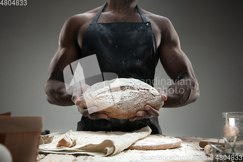 Image of Close up of african-american man cooks bread at craft kitchen