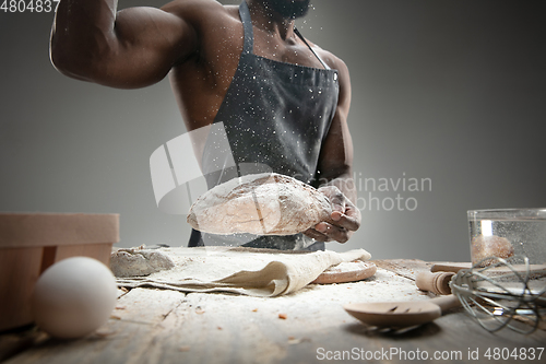 Image of Close up of african-american man cooks bread at craft kitchen