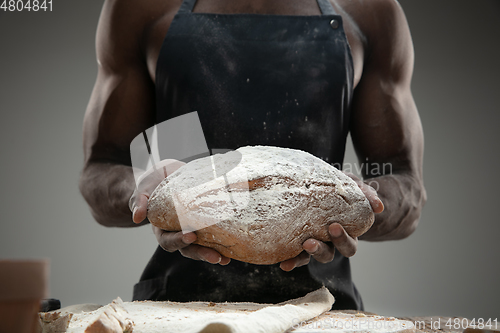 Image of Close up of african-american man cooks bread at craft kitchen