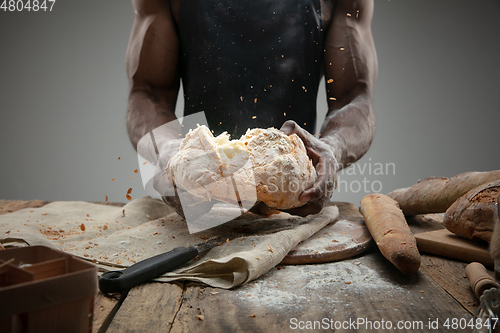 Image of Close up of african-american man cooks bread at craft kitchen