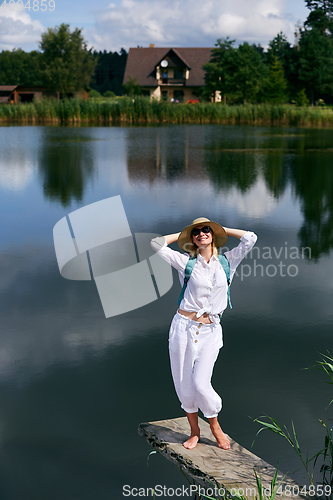 Image of Young woman resting near lake