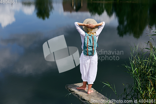 Image of Young woman resting near lake