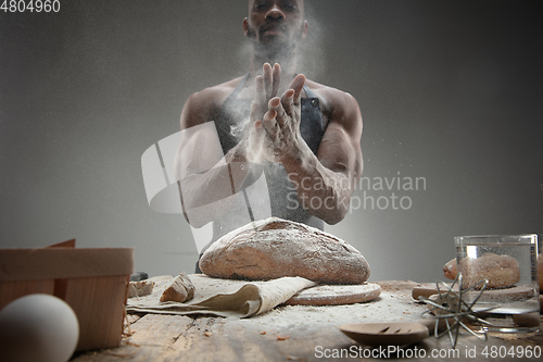 Image of Close up of african-american man cooks bread at craft kitchen
