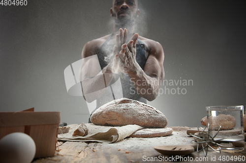 Image of Close up of african-american man cooks bread at craft kitchen