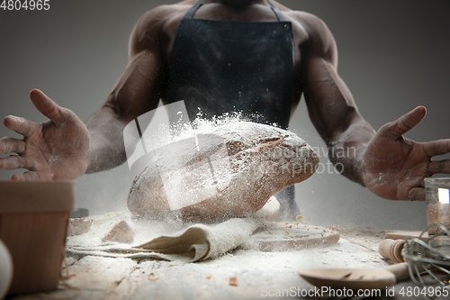 Image of Close up of african-american man cooks bread at craft kitchen