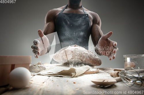 Image of Close up of african-american man cooks bread at craft kitchen