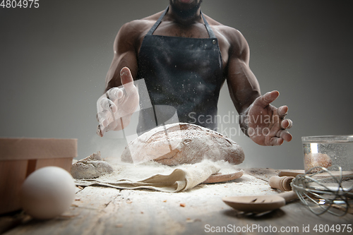 Image of Close up of african-american man cooks bread at craft kitchen