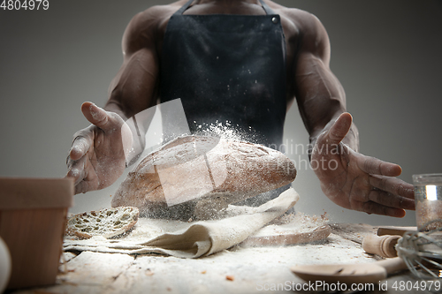 Image of Close up of african-american man cooks bread at craft kitchen