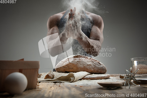 Image of Close up of african-american man cooks bread at craft kitchen